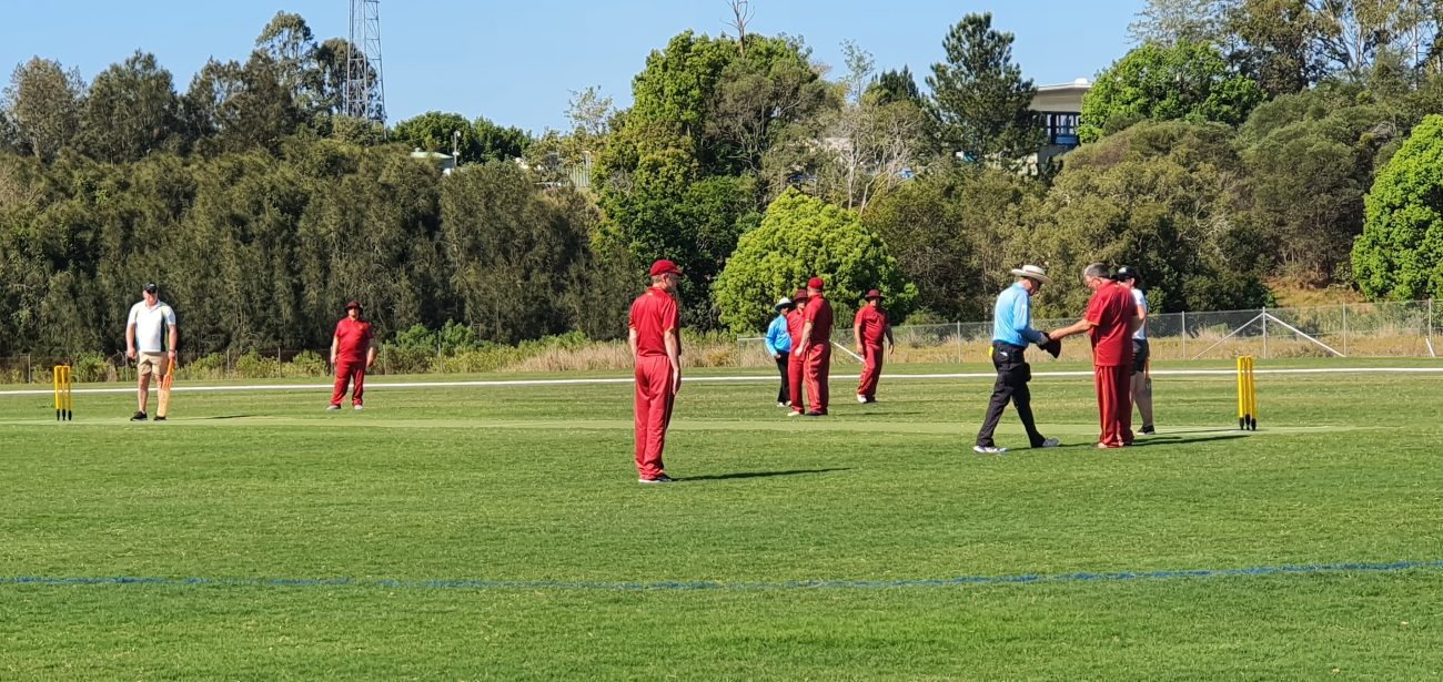 A photo of the players in the Mayor's XI match. BATs players are in maroon uniforms and the Mayor's players are in white uniforms. The Umpires are wearing blue shirts and black trouwsers.