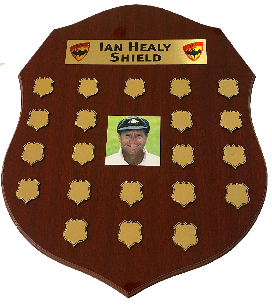 The Ian Healy Shield. Dark brown wooden sheld with 20 places to engrave annual match results. Has a phto of Ian Healy in the centrer of the shiield.