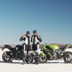 Above is a photo of Kenin Magee (World Champion GP Racer) with Ben Felton (Blind Motorcycle Speed World Record Holder). Both riders standing next to their motor bikes on the white salt flat test track.