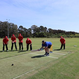 Brendon batting for the Blue Dolphins team, listens closely to the new beeping cricket ball as he readies himslf to hit the ball through the covers.