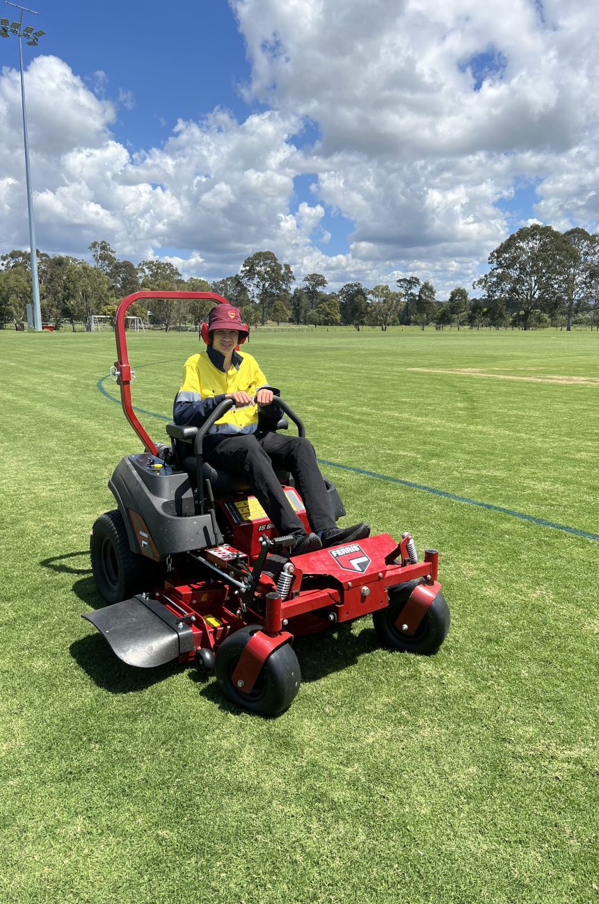 Danyil mowing the fields on our Red Ferris Zero Turn mower.