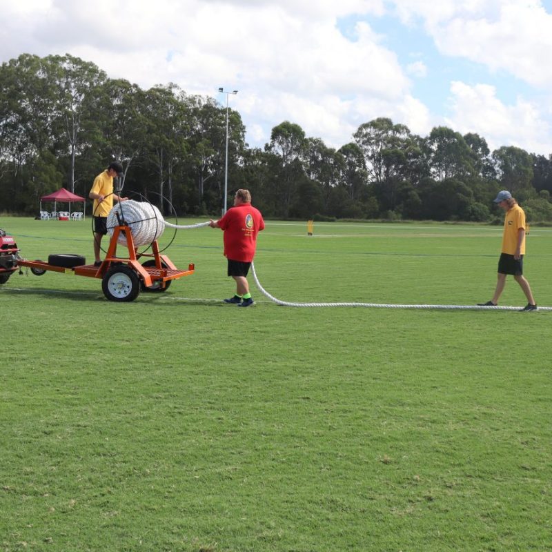 BATS Sports Club members laying out the boundary rope using their custom designed boundary rope trailor